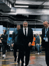 a man in a suit and tie is walking in a parking lot