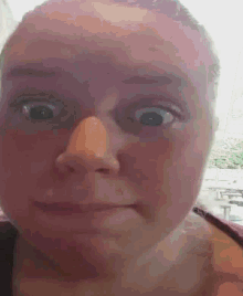 a close up of a woman 's face making a silly face