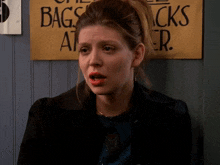 a woman standing in front of a sign that says bags