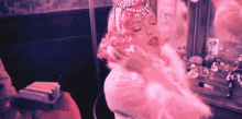 a woman wearing a pink fur coat and a tiara
