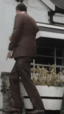 a man in a brown suit is walking down the stairs