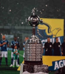a trophy with a cross on top sits on a podium