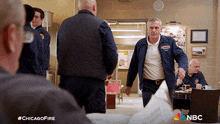 a group of men standing in a room with the hashtag #chicagofire on the bottom right