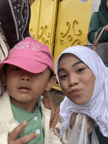a little girl wearing a pink hat that says obey on it