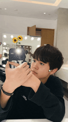 a young man taking a picture of himself with a phone that says t on it