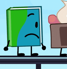 a green and blue book with arms and legs is standing on a table