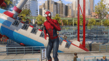 a man in a spiderman costume stands in front of a sign that says " no dogs "