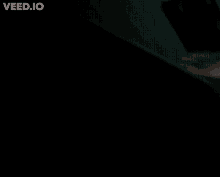 a blurry picture of a person 's arm in the dark with the website veed.io visible in the corner