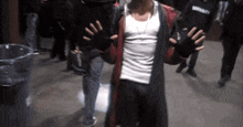 a man in a red coat holds up his hands in front of a security bag