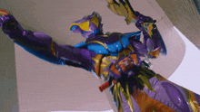 a person in a purple and blue costume is holding a gun