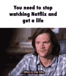 a man in a plaid shirt is sitting at a table and talking about watching netflix .