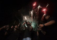 a man is holding a gun in front of fireworks