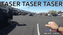 a person 's hand is pointing at a car in a parking lot with the words taser taser taser