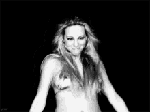 a black and white photo of a woman dancing and smiling .