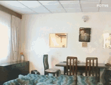 a living room with a table and chairs and a pdtv6 logo on the ceiling