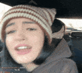 a woman wearing a knitted hat is sitting in a car with logan12wright written on the bottom right