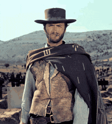 a man wearing a hat and a cape has the letter t on his shirt
