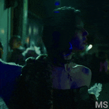 a woman with blue paint on her face and the letters ms on the bottom right
