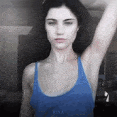 a woman in a blue tank top has the word rixa on the bottom