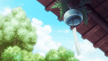 a wind chime is hanging from a roof with trees in the background