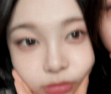 a close up of a woman 's face with a hand on her chin .