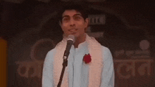 a man is standing in front of a crowd with the words ' arz kiya he ' written on the ceiling