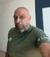 a man with a beard is wearing a green shirt that says urbi on it