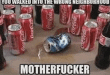 a bunch of coca cola cans and bottles on a table with a broken can in the middle .