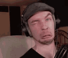 a man is wearing headphones and making a funny face .