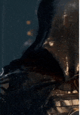 a skeleton with a hood on holds his finger to his lips