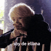 a woman with blonde hair is sitting on a chair with the words soy de eliana above her head