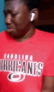 a man wearing a carolina hurricanes shirt is crying