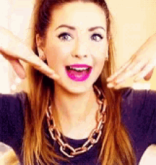 a woman wearing a chain necklace and purple lipstick is making a surprised face .