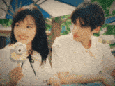 a girl holding an ice cream cone with a minion on it and a boy looking at her