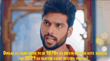 a man with a beard is standing in front of a sign that says dimag ka hard drive mein 1970s ka batein record hote