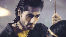 a man with wet hair is holding an umbrella in his hand