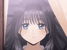 a close up of a girl 's face with long black hair and blue eyes