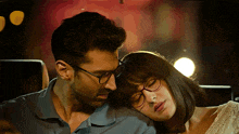 a man and a woman wearing glasses are looking at each other