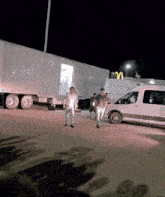 a group of people are walking in a parking lot near a mcdonalds