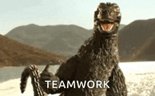a monster is holding a chain and the word teamwork is on the bottom