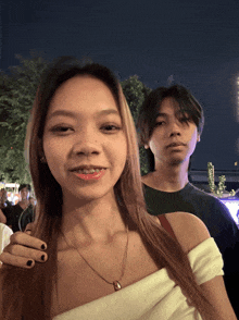 a man and woman are posing for a picture at night