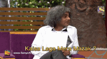 a man sitting on a couch with the words kaisa laga mera mazak written below him