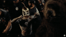 a man with a bunny mask on his face stands in a crowd