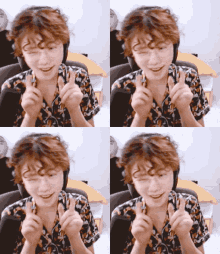 a man with curly hair is wearing headphones and making a heart shape with his fingers