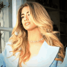 a woman with long blonde hair and hoop earrings