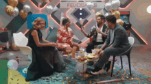 a group of people sitting around a table with a sign that says felicidades on it