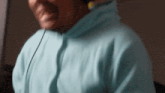 a man wearing a light blue hoodie with headphones on