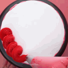 a cake is being decorated with red frosting and the words easy plus are on the bottom right