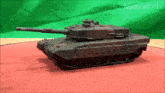 a toy tank is on a red surface with the words minicar ch on the bottom left