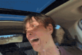a man in a car with his mouth open